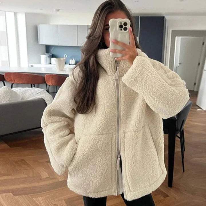 Spiegelaufnahme einer frau, die eine beige lammwolljacke trรคgt